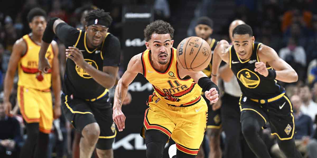Trae Young insegue la palla contro la difesa dei Golden State Warriors