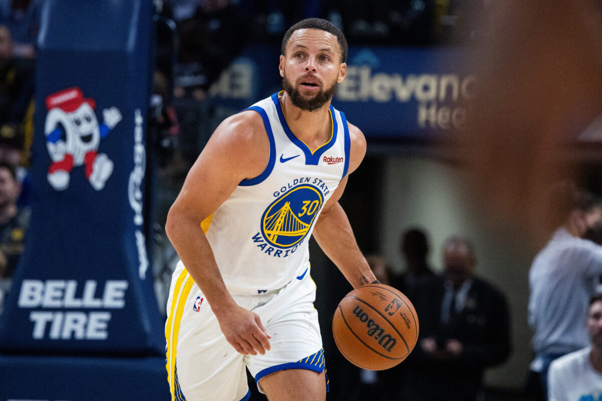 Stephen Curry in palleggio con la maglia dei Golden State Warriors