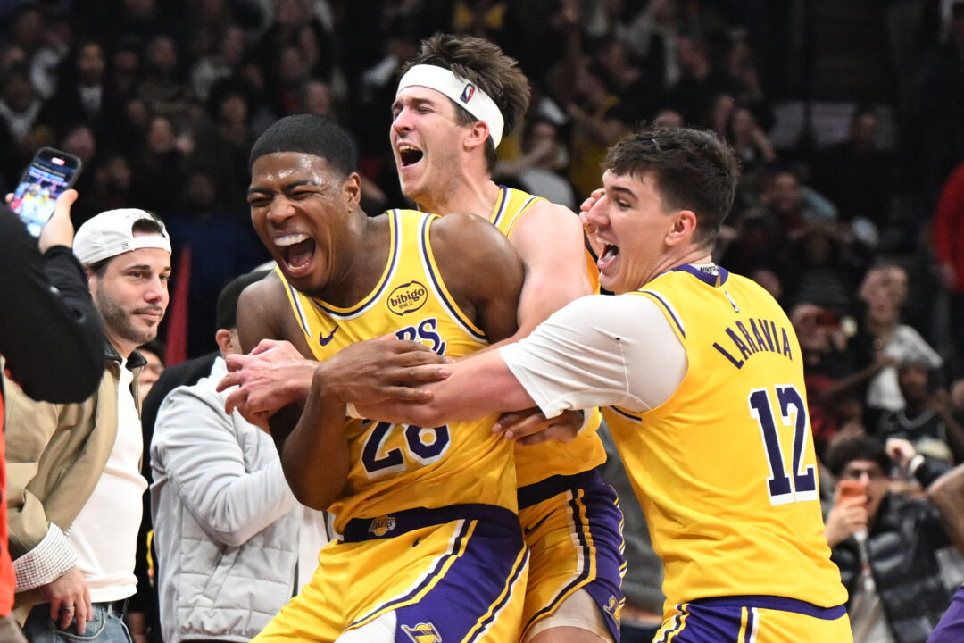 Rui Hachimura esulta con Austin Reaves e Jake LaRavia dopo aver segnato il game winner in Lakers-Raptors